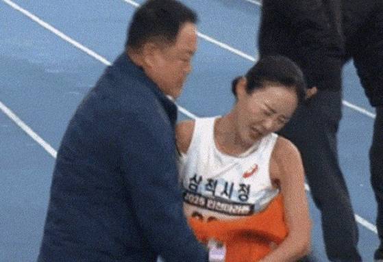 2025 인천국제마라톤 국내 여자부 우승자 이수민(삼척시청) 선수가 지난 23일 대회에서 결승선을 통과한 직후 자신을 막아세운 소속팀 김완기 감독을 뿌리치는 모습. 사진 유튜브 캡처