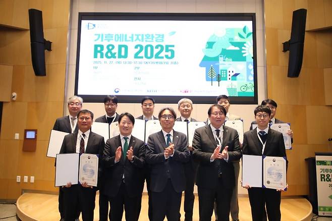 금한승 기후에너지환경부 차관(앞줄 가운데)이 27일 서울 송파구 롯데월드타워에서 열린 '기후에너지환경 연구개발(R&D) 2025'에서 환경 연구개발 우수성과 연구자, 에너지 연구개발 유공자들과 기념촬영을 하고 있다. 한국환경산업기술원 제공