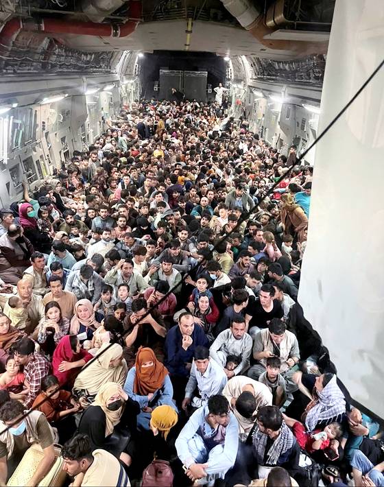 2021년 아프가니스탄을 탈출하는 아프간인 640명이 미 공군 C-17 수송기에 발 디딜틈 없이 앉아 있다. 공식 최대 탑승 인원은 134명이지만 아프간인들이 후방 적재문으로 몸을 밀어넣어 탑승했다. 로이터=연합뉴스