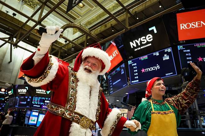 27일(현지시간) 뉴욕증권거래소 입회장에서 산타 복장을 한 직원이 인사를 하고 있다. 사진=REUTERS