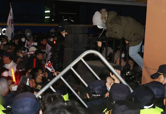 지난 1월18일 서울 마포구 서울서부지법에서 열린 윤석열 전 대통령의 구속 전 피의자심문 뒤 윤 전 대통령 지지자들이 법원 담장을 넘고 있다. 공동취재사진