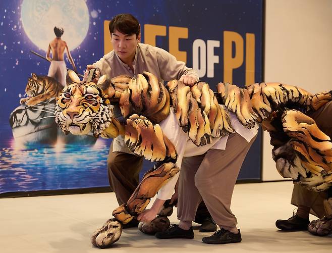 Puppeteer Kim Si-young (left) demonstrates Richard Parker, a Bengal tiger, for "Life of Pi," during a press conference on Nov. 27. (S&Co)
