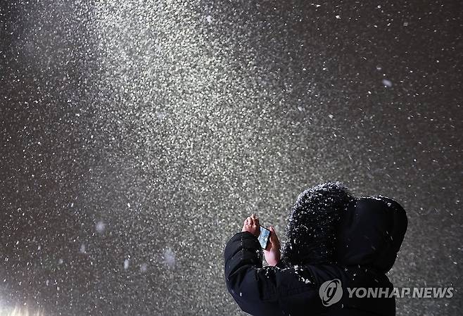 첫눈 인증 (수원=연합뉴스) 홍기원 기자 = 4일 경기도 수원시 화성행궁 광장에서 시민이 올겨울 첫눈 사진을 찍고 있다. 2025.12.4 xanadu@yna.co.kr