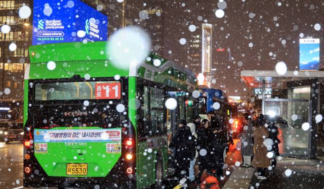▲ 서울 지역에 올해 첫눈이 내린 4일 서울 광화문에서 시민들이 버스에 탑승하고 있다. 2025.12.4 연합뉴스