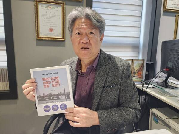 ▲ 진천규 통일TV 대표가 자신의 저서 '평양의 시간은 서울의 시간과 함께 흐른다'를 들고 있는 모습. 사진=장슬기 기자