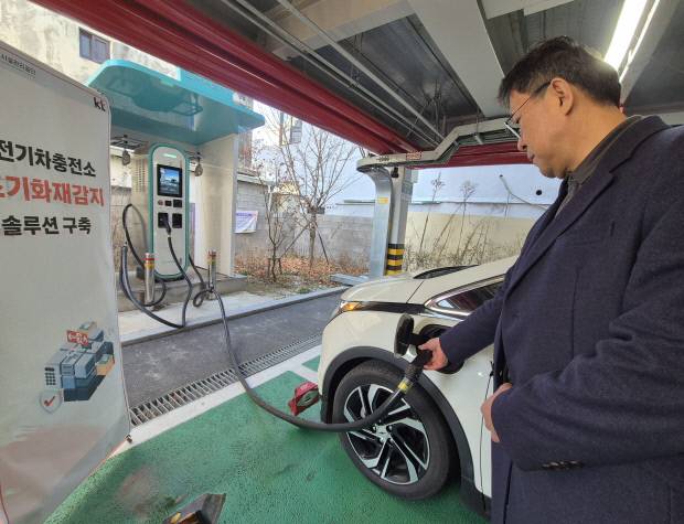 조기 화재 감지 솔루션이 구축된 경주 중심상가 공영주차장에서 한 시민이 전기차 배터리를 충전하고 있다. 사진 속 아래 빨간색 이미지가 세이프 메이트 'IoT복합 화재감지기'다. 사진=KT대구경북광역본부 제공