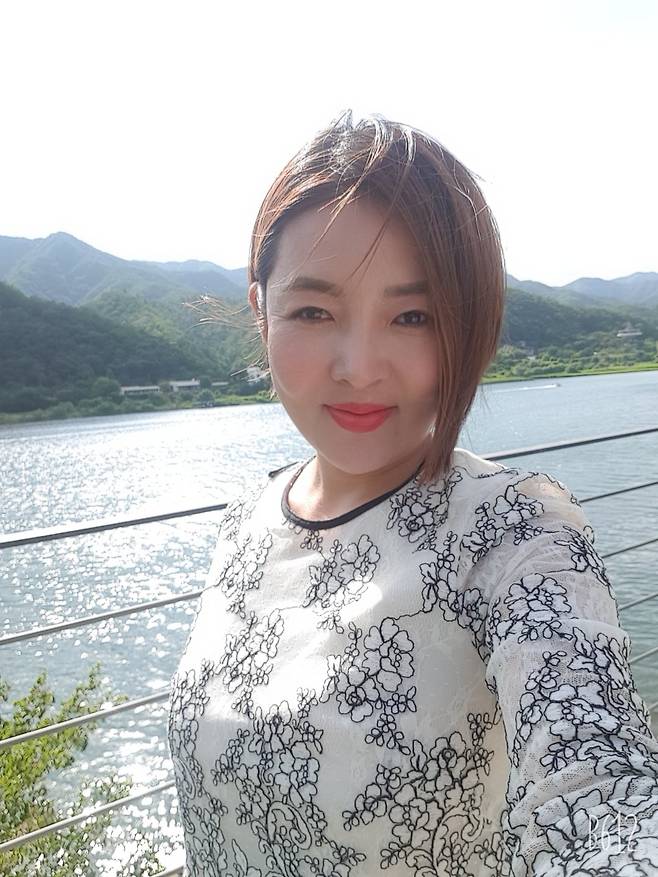 2016년 중고차 판매왕 워크샵에 참가한 이유미 씨가 남한강을 배경으로 셀피를 찍고 있다.