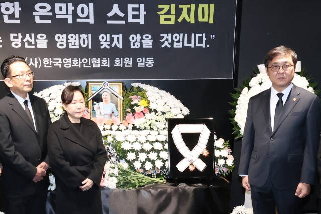 최휘영(오른쪽) 문화체육관광부 장관이 14일 오후 서울 중구 충무로 서울영화센터에 마련된 원로배우 고 김지미 추모공간에서 금관문화훈장을 전달한 뒤 유족 및 영화업계 관계자들과 기념촬영을 하고 있다. 연합뉴스