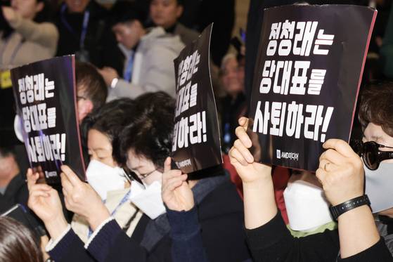 일부 더불어민주당 당원들이 14일 오후 국회 의원회관에서 열린 창당 70주년 당원의 날 행사에 참석해 정청래 대표의 사퇴를 촉구하는 손팻말 시위를 벌이고 있다. 장진영 기자