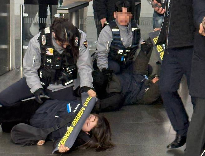 경찰이 지난 10일 서울 송파구 쿠팡 본사에서 기습시위를 벌이던 공공운수노조 쿠팡물류센터지회 관계자를 연행하고 있다. X(옛 트위터) 갈무리