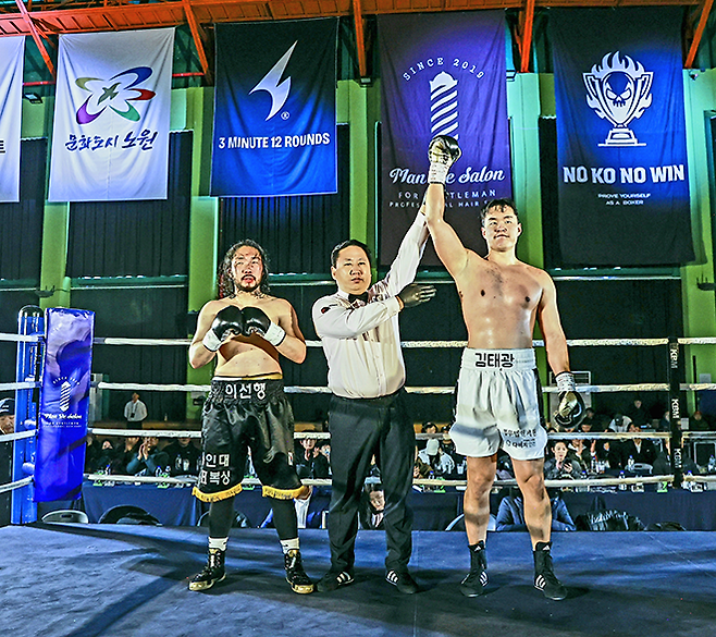 김태광이 2025년 12월 서울특별시 노원구 육사체육관 사단법인 한국복싱커미션 KBM 헤비급 챔피언결정전에서 손경수 주심의 승리 선언을 받고 있다. 왼쪽은 패배를 인정하는 이선행. 사진=FINAL FLASH 박종혁 작가 제공