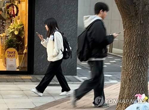 휴대폰 보며 걸어가는 청소년 (서울=연합뉴스) 이진주 인턴기자 = 지난 14일 양천구 학원가에서 청소년들이 휴대폰을 보며 걸어가고 있다. 2025.12.18
