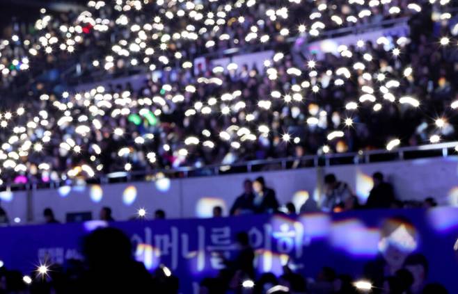 참석자들이 안치환의 노래 ‘사람이 꽃보다 아름다워’에 맞춰 휴대전화 불빛과 응원봉을 흔들고 있다.