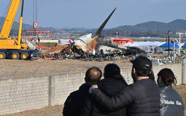 제주항공 여객기 참사 당시 사고 현장에서 유가족들이 여객기 잔해를 바라보고 있는 모습. <광주일보 자료사진>