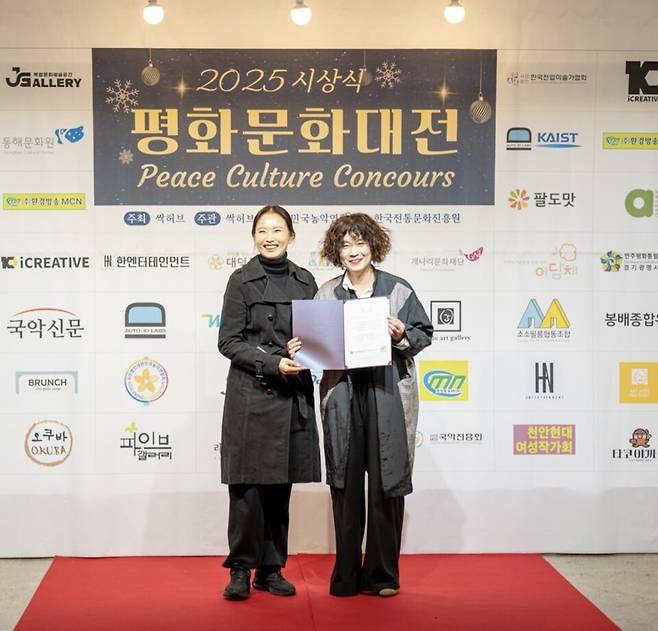 ▲2025 평화문화대전 시상식에서 김득(왼쪽) 위원장과 추윤경 작가/사진제공=싹허브