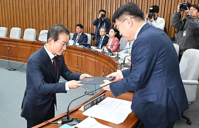 김호철 감사원장 후보자가 29일 서울 여의도 국회에서 열린 인사청문회에 출석해 인청특위 위원장인 정점식 국민의힘 의원에게 선서문을 제출하고 있다. 이상섭 기자