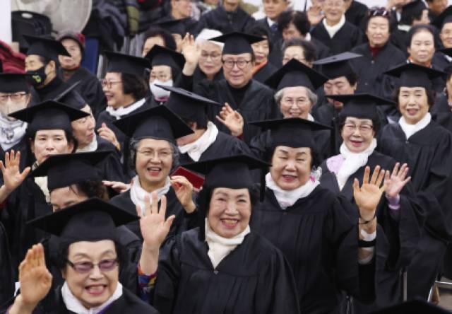 지난달 29일 경기도 안양시 동안노인복지회관에서 열린 '노인대학 제29기 졸업식'에서 학사모를 쓴 어르신들이 손을 흔들고 있다. 연합뉴스.