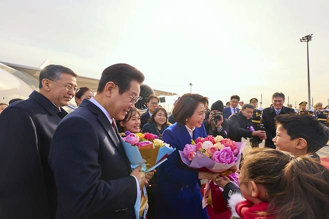 ▲ 중국을 국빈방문한 이재명 대통령과 김혜경 여사가 4일 베이징 서우두 공항에서 화동의 꽃다발을 받고 있다.연합