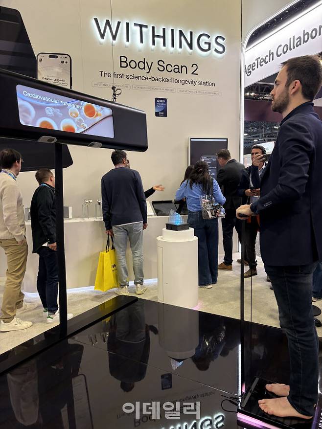 한 관람객이 위딩스(WITHINGS)의 바디스캔2에 올라 심혈관 검사를 진행해보고 있다. (사진=김소연 기자)
