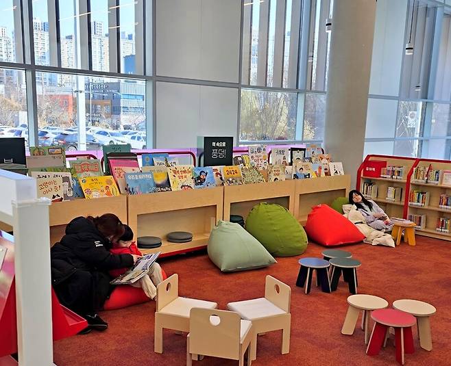 경기 파주시 문산도서관 1층과 2층 사이 경사면 통로를 따라 조성된 어린이자료실에서 엄마와 아이들이 책을 보거나 휴식을 취하며 여유로운 시간을 보내고 있다. 송상호 기자