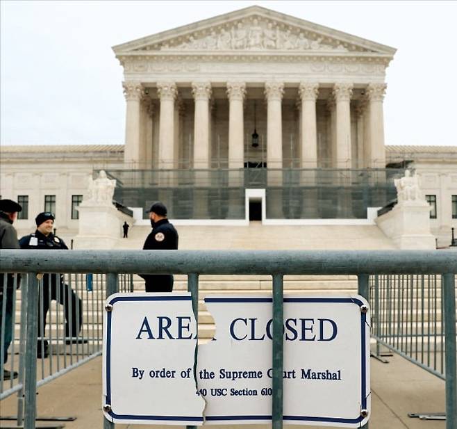 < 상호관세 운명은…> 지난 9일 미국 워싱턴DC 연방대법원 앞에 법원 경찰들이 배치돼 있다. 미 연방대법원은 이르면 오는 14일 상호관세가 적법한지 여부를 판결할 것으로 예상된다. 로이터연합뉴스