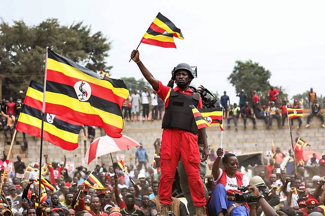우간다 국민통합플랫폼의 대통령 후보인 보비 와인(본명 로버트 캬굴라니)이 지난 9일(현지시간) 우간다 무코노에서 열린 유세 현장에서 국기를 흔들고 있다. AP연합뉴스