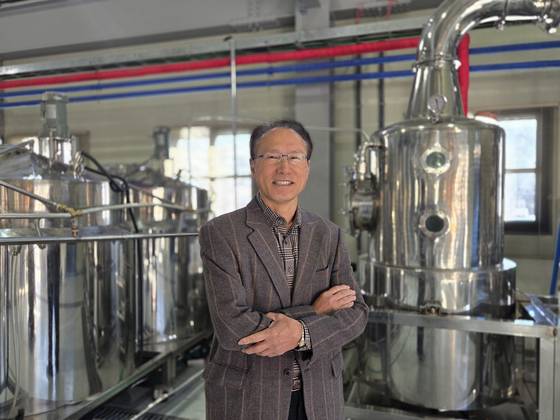 충북 청주에 위치한 '스마트부루어리' 공장 안의 증류기 앞에서 오세용 대표가 활짝 웃고 있다. 김경진 기자
