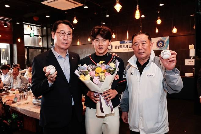 롯데에 입단하는 박찬형(가운데)이 프로 진출 후 본인의 사인 1호, 2호 공을 화성특례시 정명근 시장(왼쪽)과 박종선 화성시체육회장(오른쪽)에게 전달하는 모습. 사진 | 화성시 코리요