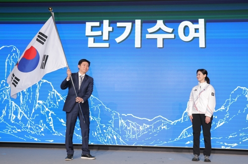 22일 서울 올림픽파크텔에서 열린 2026 밀라노 동계올림픽 선수단 결단식에서 유승민 대한체육회장이 이수경 선수단장에게 단기를 건네고 있다. 연합