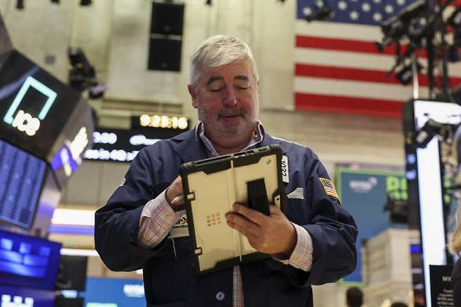 뉴욕증권거래소에서 한 트레이더가 태블릿PC로 거래 동향을 파악하고 있다. (사진=AFP)