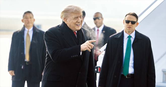 기체 이상으로 전용기 갈아타고 온 트럼프 스위스 다보스에서 열리는 세계경제포럼 참석차 21일 취리히 공항에 도착한 도널드 트럼프 미국 대통령이 전용기에서 내린 뒤 수행원들에게 손짓하고 있다. 트럼프는 전날 백악관에서 취임 1주년 기자회견을 마친 뒤 전용기편으로 다보스로 향했다가, 기체의 전기 계통 이상으로 회항해 예비 항공기로 갈아타고 다시 출발했다./ AP 연합뉴스