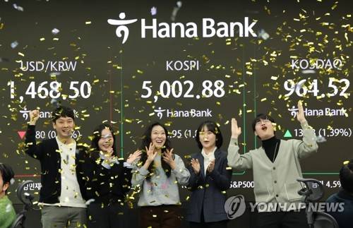 코스피가 장중 5000을 넘어선 가운데 22일 오전 서울 중구 하나은행 딜링룸에서 딜러들이 기뻐하고 있다. 연합뉴스