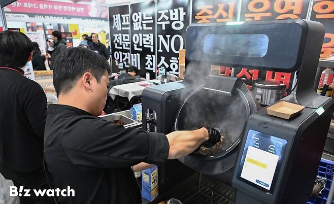 15일 서울 강남구 코엑스에서 열린 '프랜차이즈 창업 박람회 2026'을 찾은 관람객들이 '셰프없는주방' 슬로건을 내세운 중화요리점 부스를 둘러보고 있다./사진=이명근 기자 qwe123@