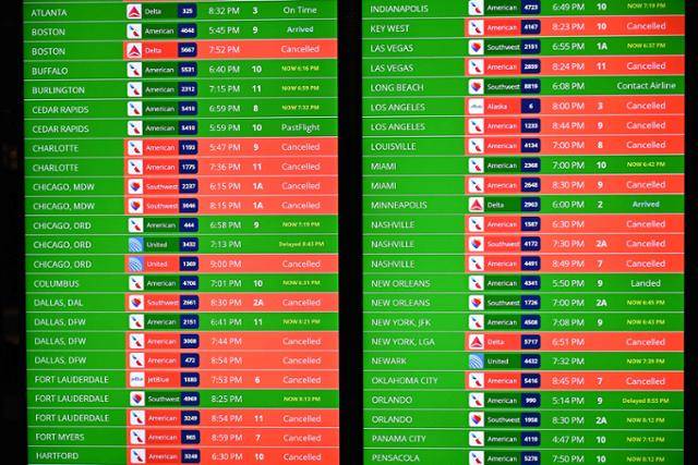 강력한 눈 폭풍이 북미 지역을 강타한 24일 미국 워싱턴 인근 로널드 레이건 공항의 비행 정보 표시판이 무더기로 결항된 항공편을 보여 주고 있다. 워싱턴=AFP 연합뉴스