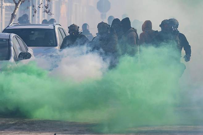 24일(현지시간) 미네아폴리스에서 연방 요원들이 시위대에게 최루 가스를 발사하고 있다. AP=연합뉴스
