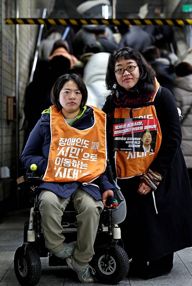 비장애인 활동가 한명희(오른쪽)씨와 장애인 활동가 문애린씨가 2026년 1월19일 오전 서울 종로구 지하철 4호선 혜화역 승강장에서 열린 \'열차가 어둠을 헤치고, 출근길 지하철 선전전 1000일\'에 함께 걸어가고 있다. 이종근 선임기자