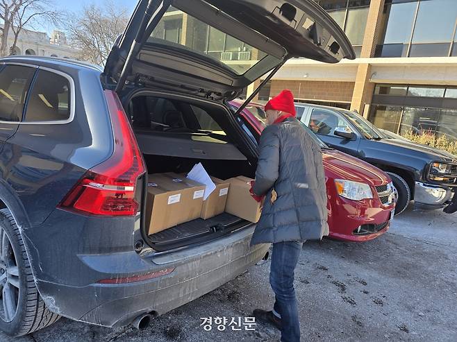 미국 미니애폴리스의 호텔·레스토랑 노조 상근 직원인 웨이드 루넨버그가 28일(현지시간) 이민단속 위험으로 집 밖에 나오지 못하는 노조원들에게 배달할 식량 상자를 차에 싣고 있다. 미니애폴리스 | 정유진 특파원
