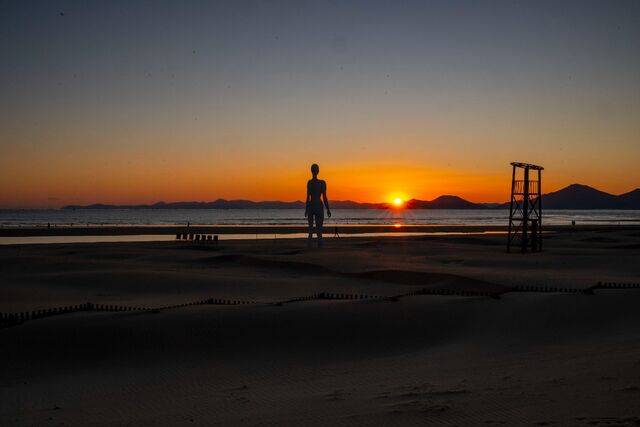 다대포해수욕장 뒤 가덕도 등대 쪽으로 해가 넘어가며 주변을 붉게 물들이고 있다.