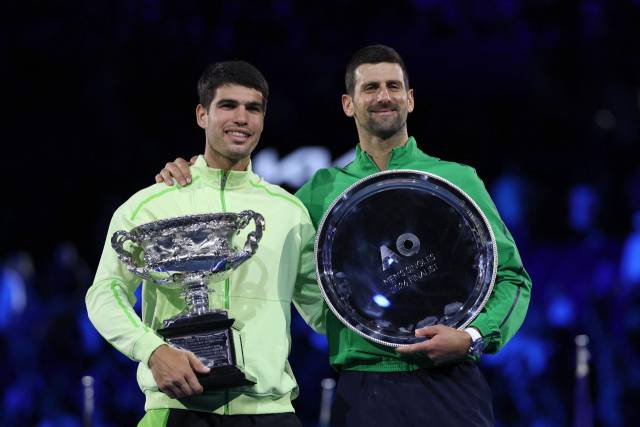 카를로스 알카라스(왼쪽)가 1일 호주 멜버른에서 열린 호주오픈 테니스 대회 남자 단식 정상에 올라 우승 트로피를 들고 기념 사진을 찍고 있다. 오른쪽은 결승에서 알카라스에 패한 노박 조코비치. AFP 연합뉴스