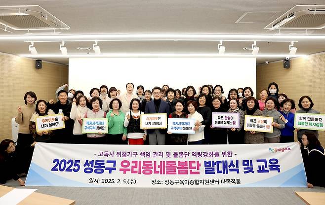 여러 사람이 피켓을 들고 배너 앞에서 단체 사진을 찍고 있는 모습이다. 배너에는 ‘2025 성동구 우리동네돌봄단 발대식 및 교육’이라고 적혀 있다.