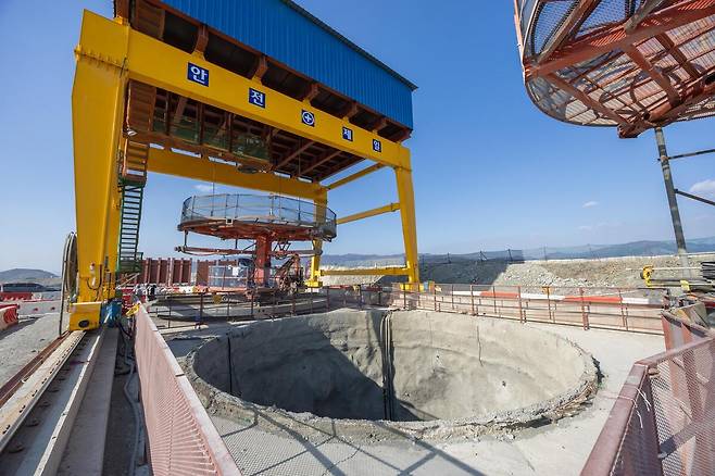 부산항 신항 북측 컨테이너부두 2단계 항만배후단지 조성 공사 현장의 갠트리 크레인 아래에 굴착이 완료된 수직터널이 자리해 있다. DL이엔씨 제공