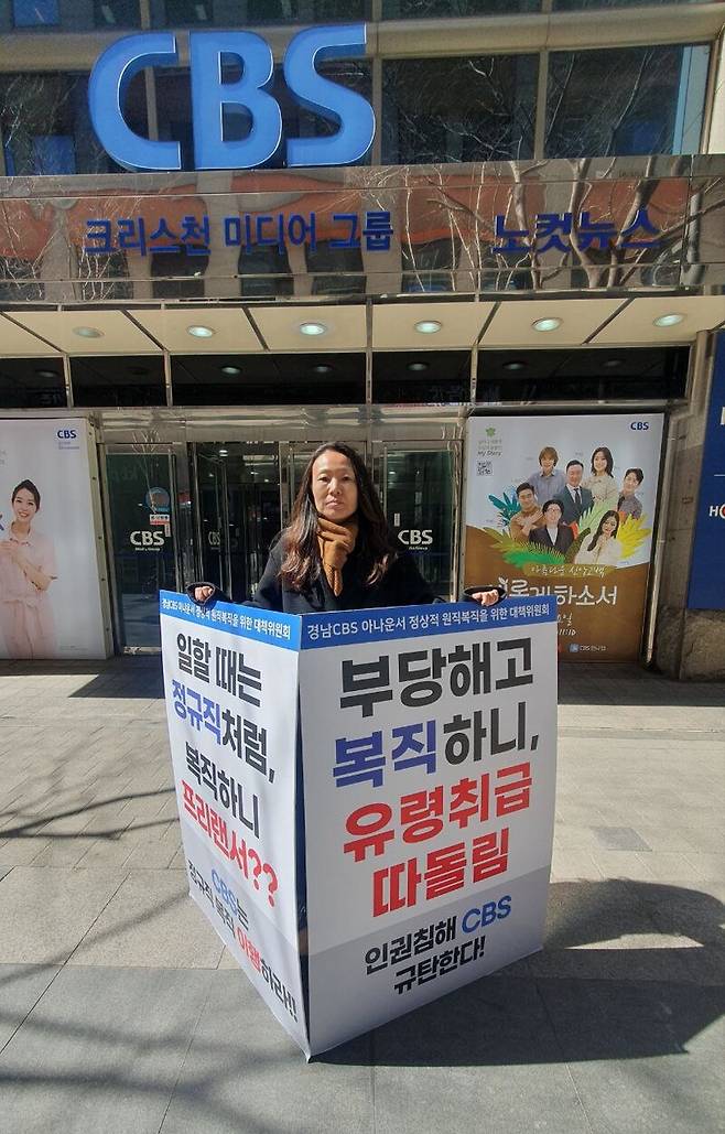 ▲김유경 돌꽃 노동법률사무소 노무사가 2023년 3월13일 서울 목동 CBS 앞에서 1인 시위 중이다. '경남CBS 아나운서 정상적 원직복직을 위한 대책위원회'는 지난 1월25일부터 경남CBS와 서울 CBS본사 앞에서 최태경 아나운서의 정상 원직 복직을 촉구하며 1인 시위를 진행하고 있다. 대책위 제공