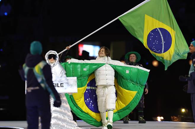 6일(현지시간) 이탈리아 밀라노 산시로 스타디움에서 열린 2026 밀라노 코르티나 동계올림픽 개막식에서 브라질 선수단이 몽클레르에서 제작한 단복을 입고 입장하고 있다. /신화 연합뉴스