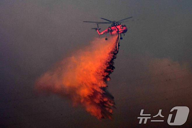 8일 경북 경주시 문무대왕면 입천리에서 발생한 산불이 강풍을 타고 확산되고 있는 가운데 산림청 초대형헬기(S-64) 헬기가 송전선로를 피해 진화 작업을 벌이고 있다. 이날 오후 정부는 신속한 진화를 위해 국가소방동원령을 발령했다. 2026.2.8 ⓒ 뉴스1 최창호 기자
