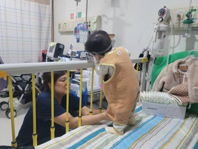 4일 저녁 하늘이와 양미영 간병인이 강원대병원 어린이병동 병실에서 시간을 보내고 있다. 2024년 6월 태어나 19개월 째 병실에서 지내고 있는 하늘이의 키는 77.5㎝로, 19개월 평균(83.2㎝)보다 약 6㎝ 작다. 이설화 기자