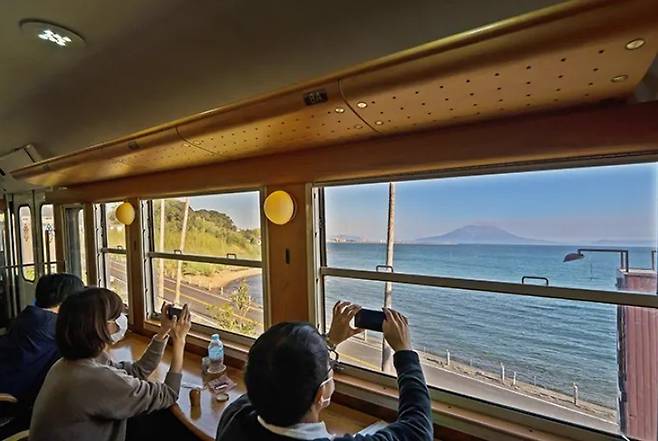 화산이 깊은 인상을 남기는 사쿠라지마섬이 열차 안에서 또렷하게 보입니다. 이 화산섬은 가고시마 항구에서 페리를 타고 15분 거리에 있습니다.(일본정부관광국 제공)