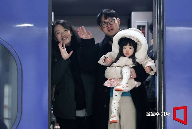설 명절연휴를 앞둔 13일 서울역에서 귀성객이 고향으로 향하는 KTX열차에 올라 손을 흔들고 있다. 윤동주 기자