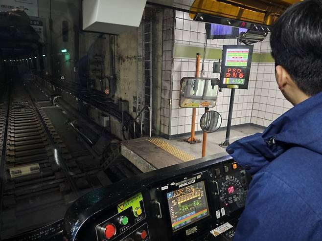 이상헌 기관사(35)가 출발 직전 기관실 우측 상단 CCTV를 통해 스크린도어 승객 탑승 상황을 확인하고 있다.