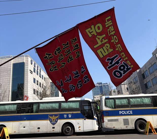 19일 오전 서울 서초구 중앙지방법원 인근 도로에 경찰 버스가 차벽으로 세워진 가운데, ‘윤석열 사형’ 문구가 적힌 현수막이 도로 위에 걸려 있다. 박지우 견습기자