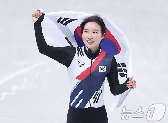 쇼트트랙 김길리가 20일(현지시간) 이탈리아 밀라노 아이스 스케이팅 아레나에서 열린 2026 밀라노·코르티나담페초 동계올림픽 쇼트트랙 여자 1500m 결승에서 금메달을 확보한 후 태극기를 두른 채 인사하고 있다. 2026.2.21 ⓒ 뉴스1 김성진 기자